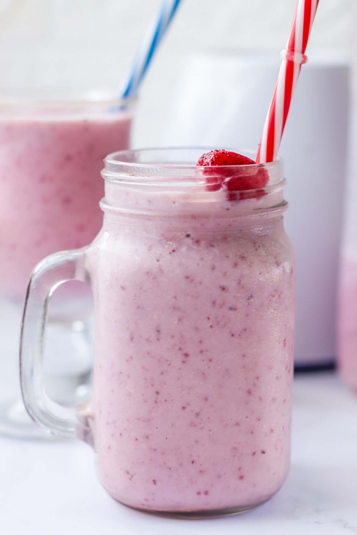 Pink milkshake in a mason jar.