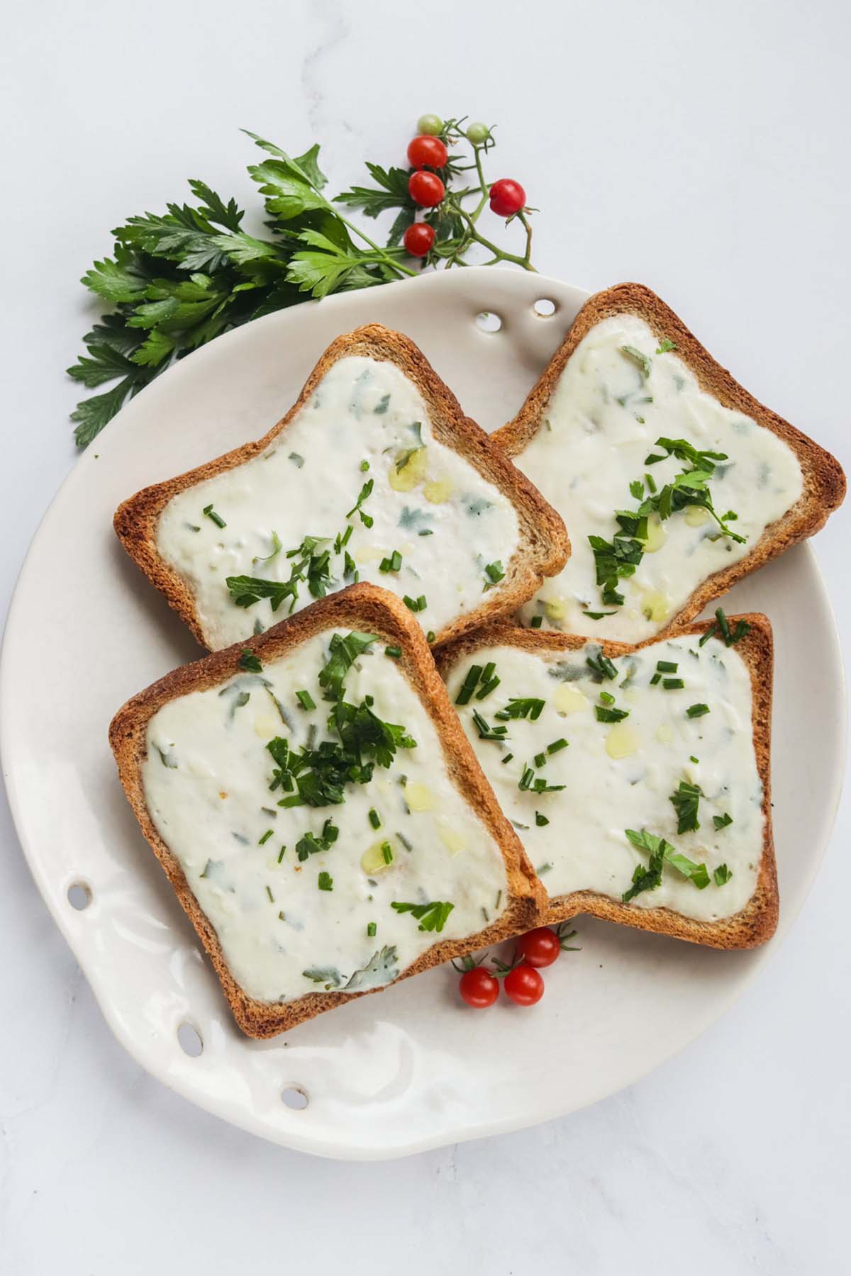 Garlic bread on a plate topped with chopped parsley.