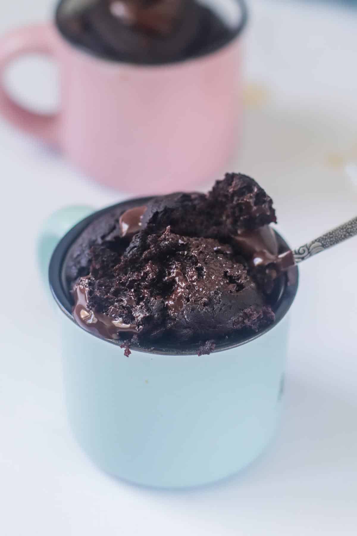 Cake in a mug scooped on a spoon.
