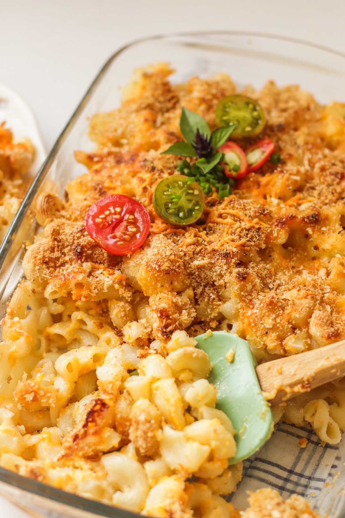 A spatula in the baking dish with the mac and cheese.