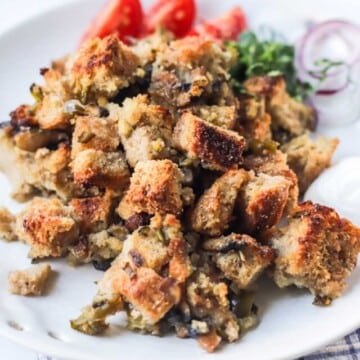 Stuffing on a white plate set on a kitchen towel.