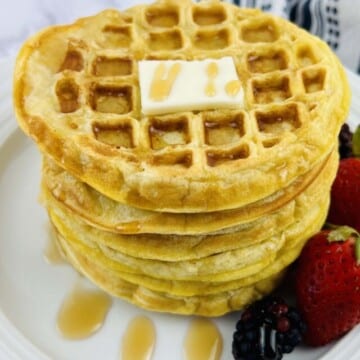 A stack of waffles on a white plate.