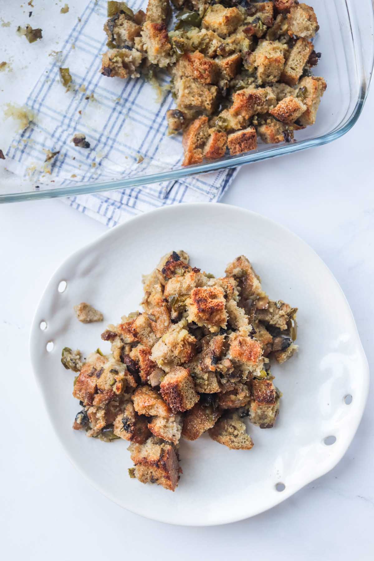 Stuffing on a plate next to the baking dish.