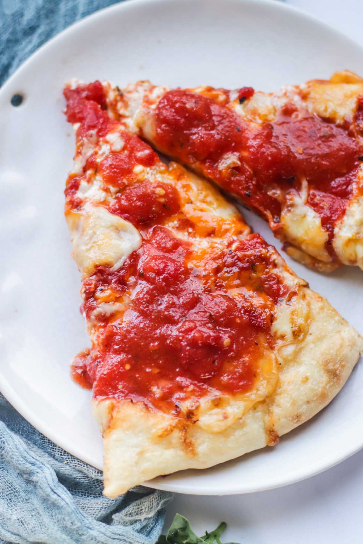 Pizza sauce spread on pizza slices.