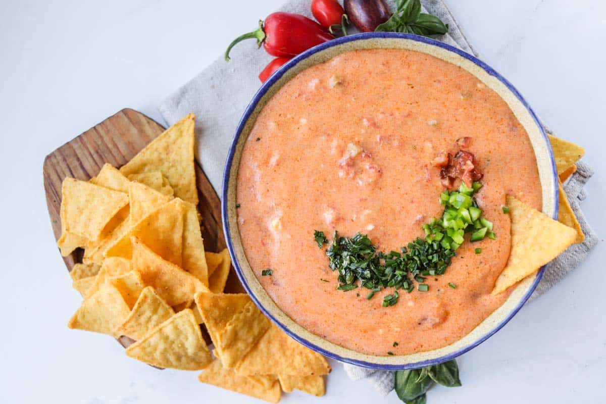 Queso dip in a bowl with chips.