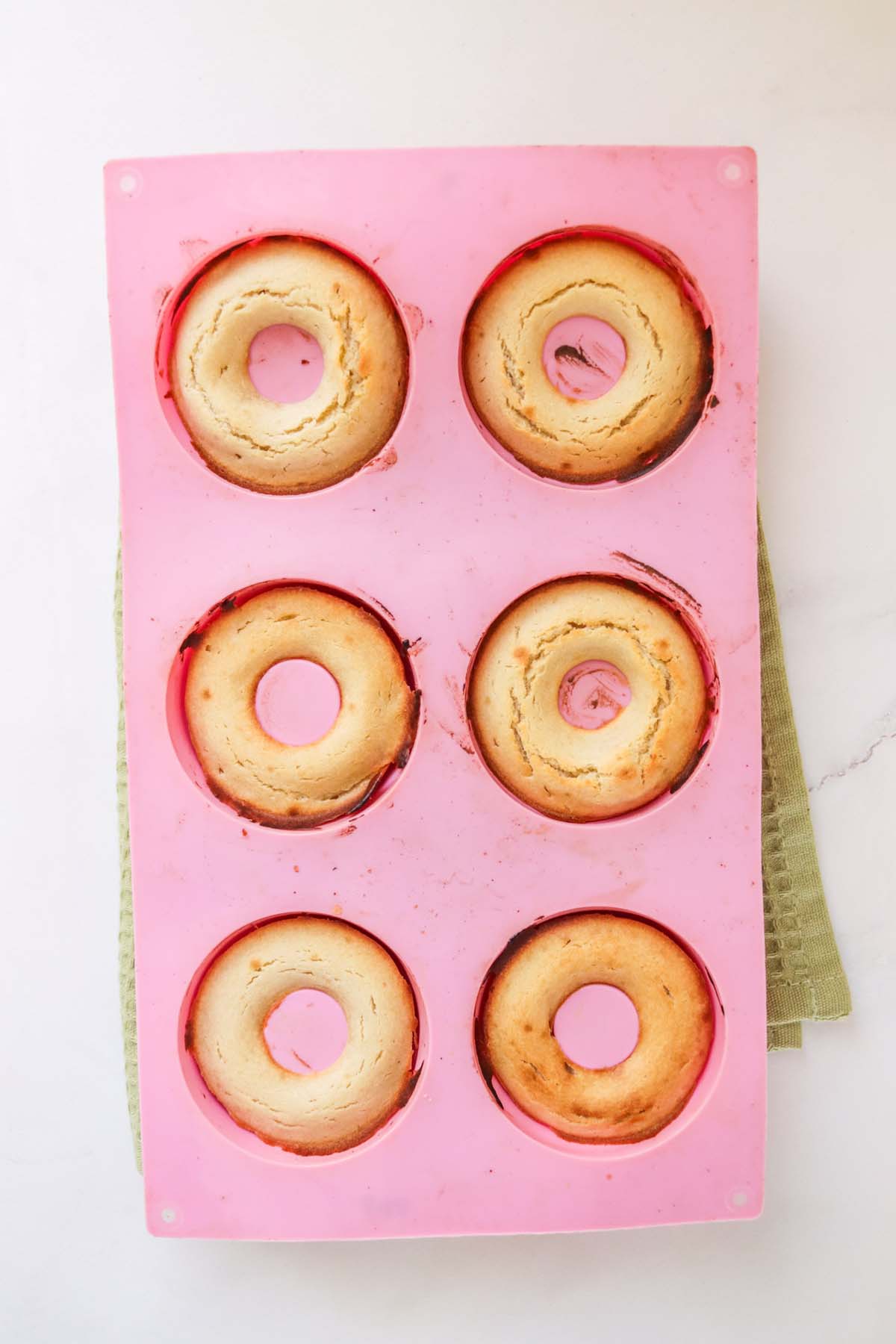 Baked donuts in a donut pan.