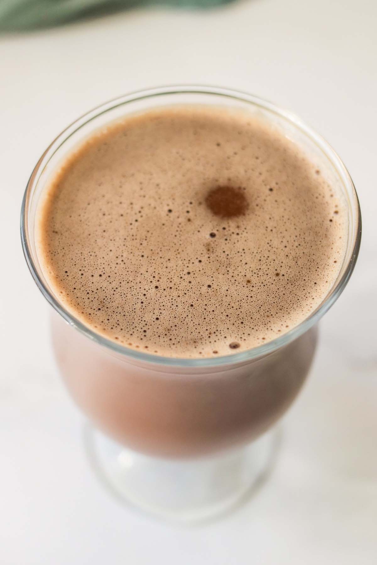 Chocolate milk with foam on top.