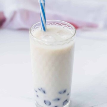 Bubble tea in a glass with a blue straw.