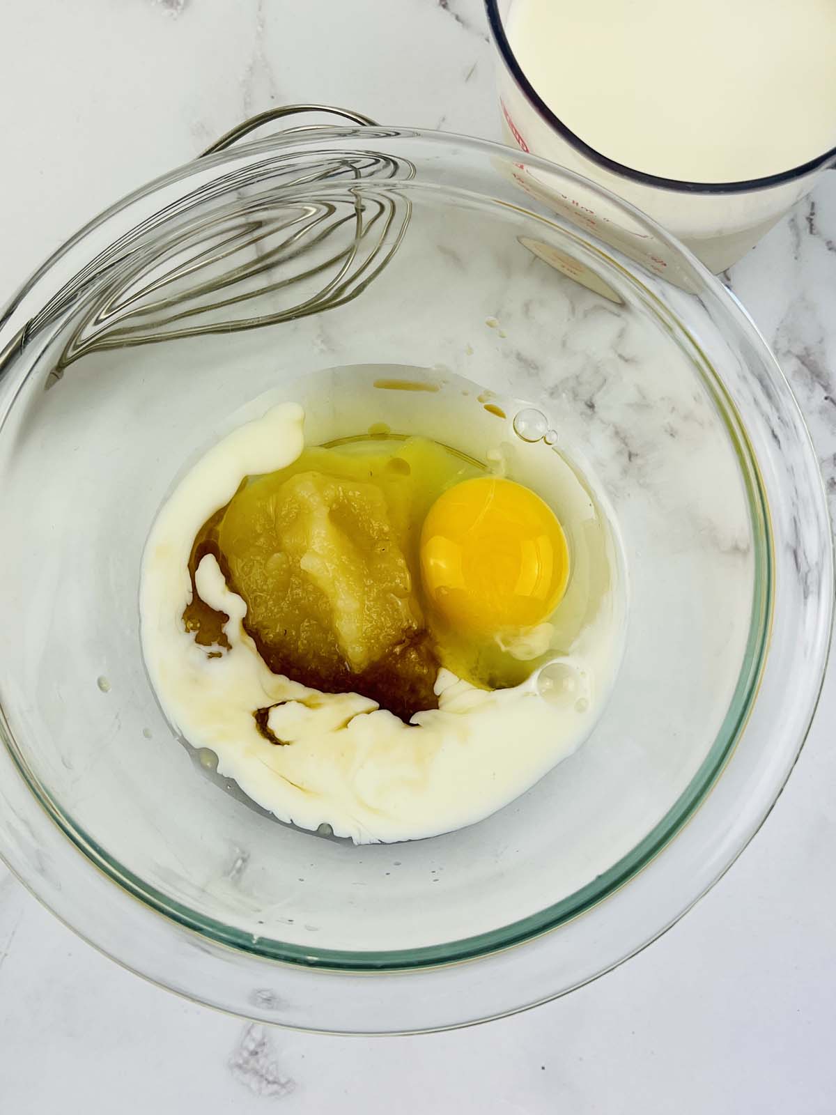 Eggs and applesauce in a mixing bowl.