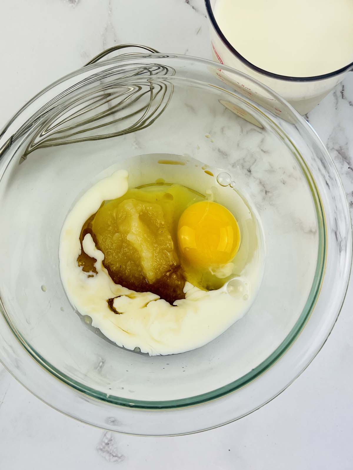Eggs and applesauce in a mixing bowl.