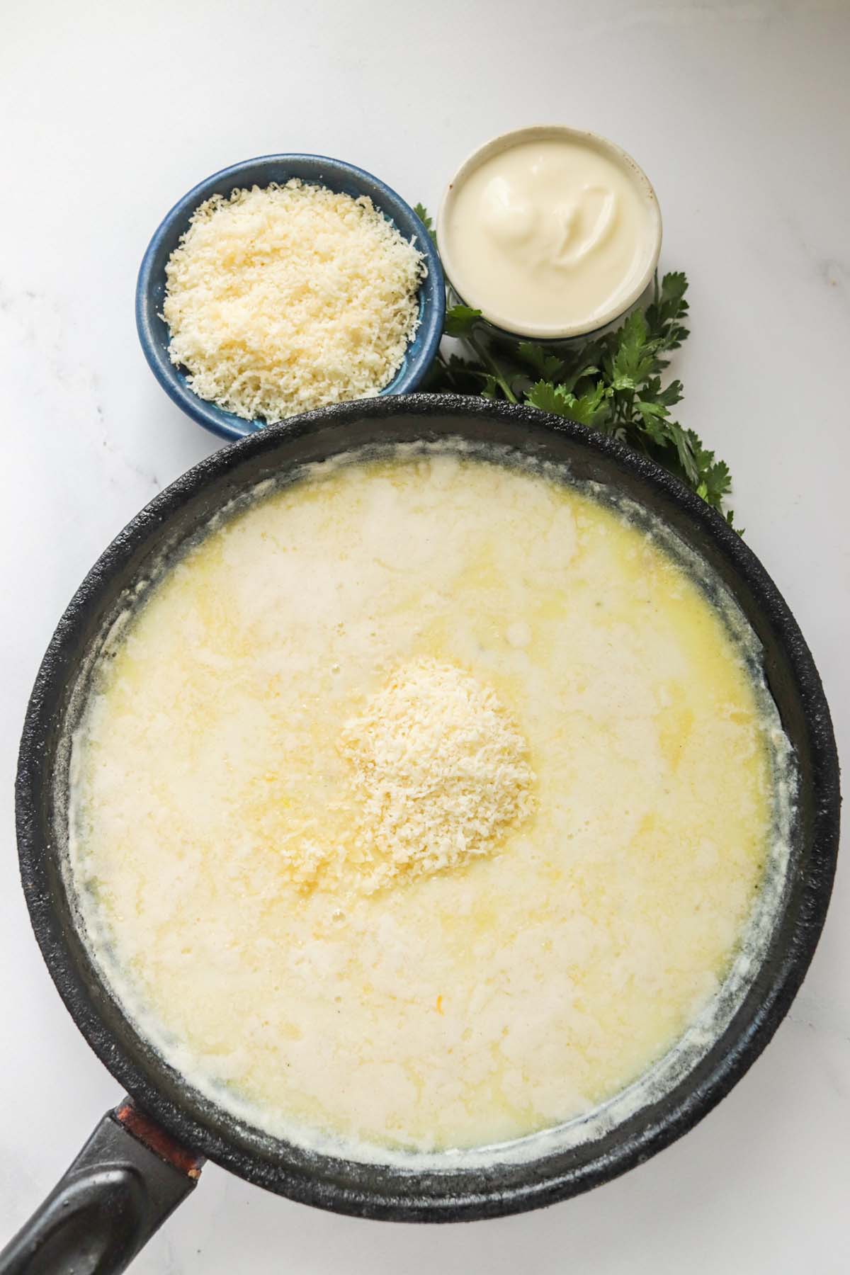 Cheese being added to the sauce.