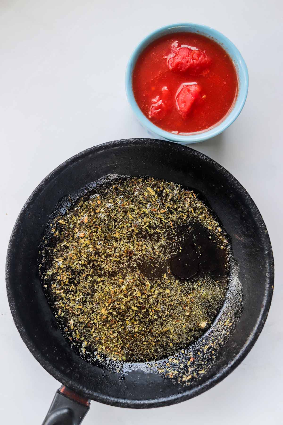 Oil and spices combined in a skillet.