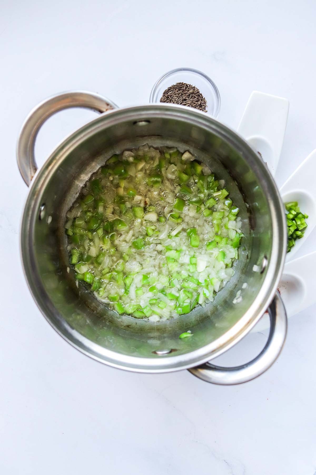 Bell peppers and onions in a pot.