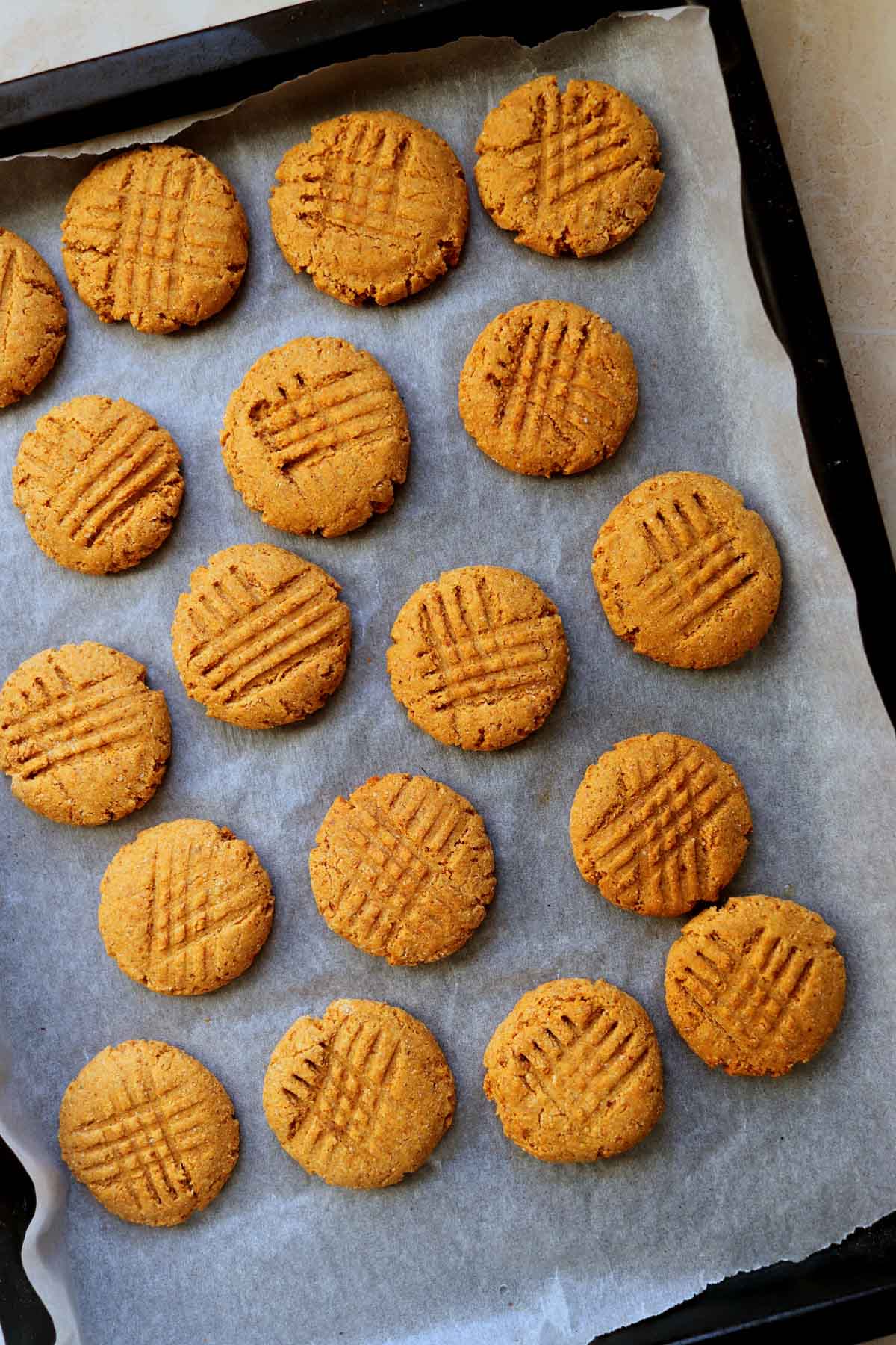 Baked cookies on a baking sheet lined with parchment paper.