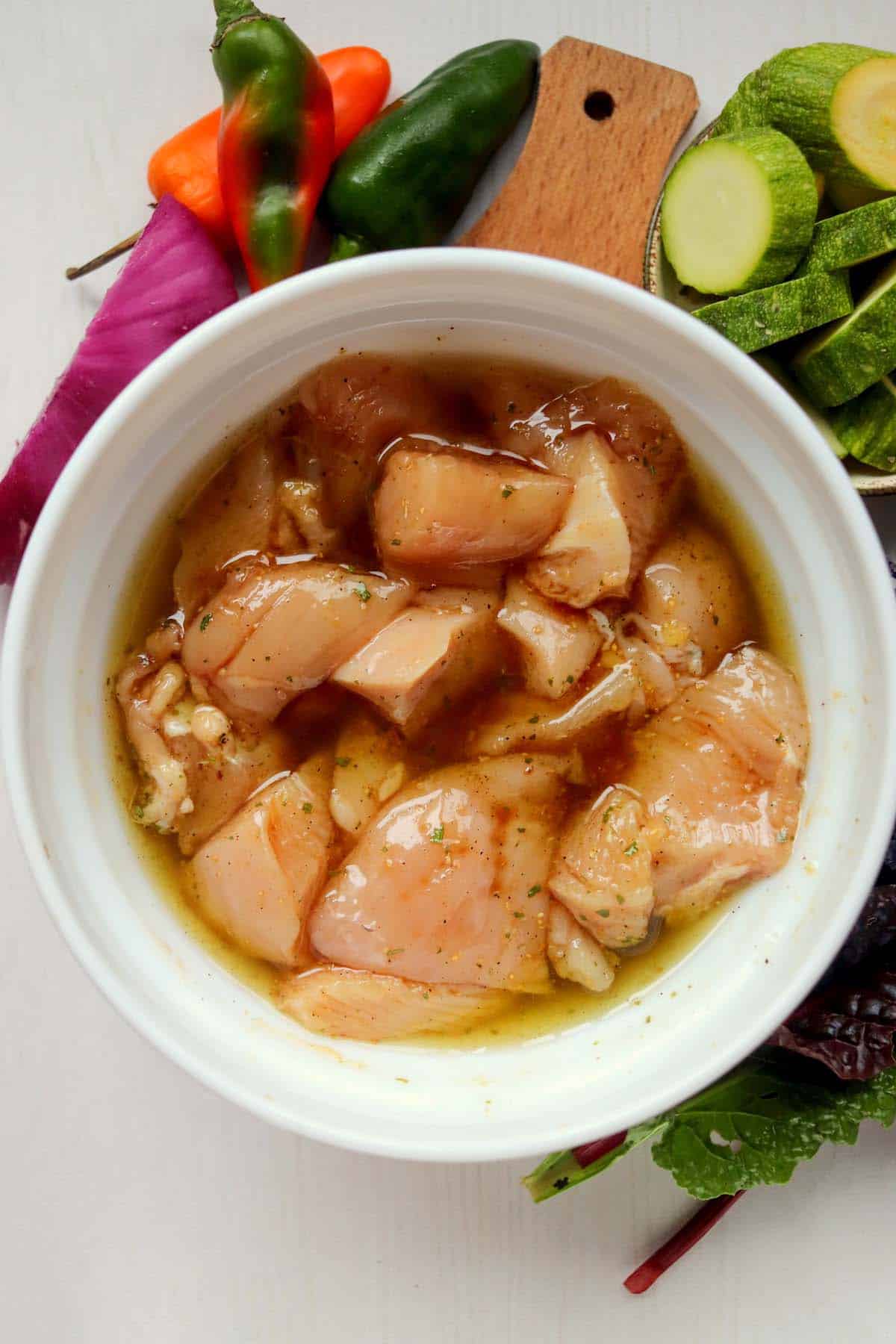 The chunks of chicken in the marinade.