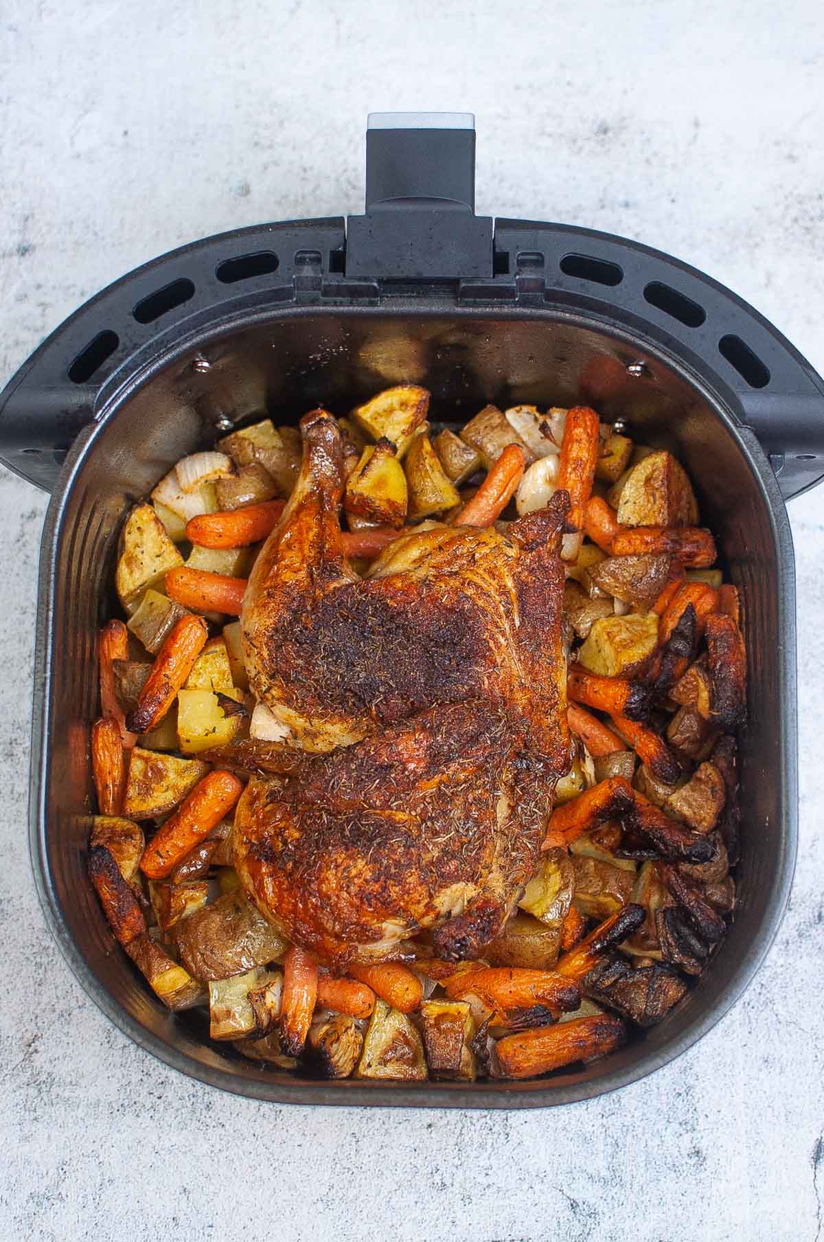 Cook chicken and vegetables in the air fryer basket.