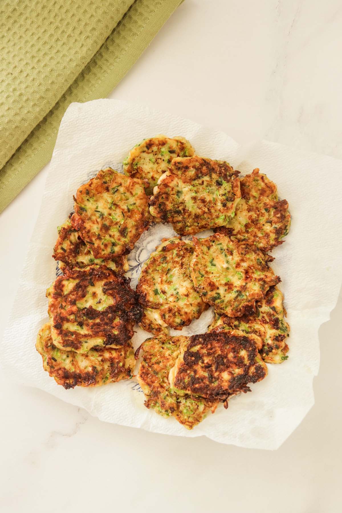 Cook fritters on a plate lined with a paper towel.