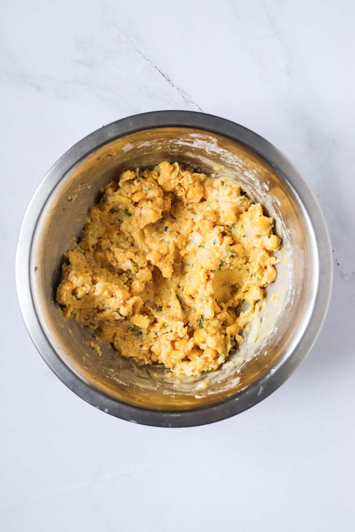 The corn fritter mixture in a mixing bowl.