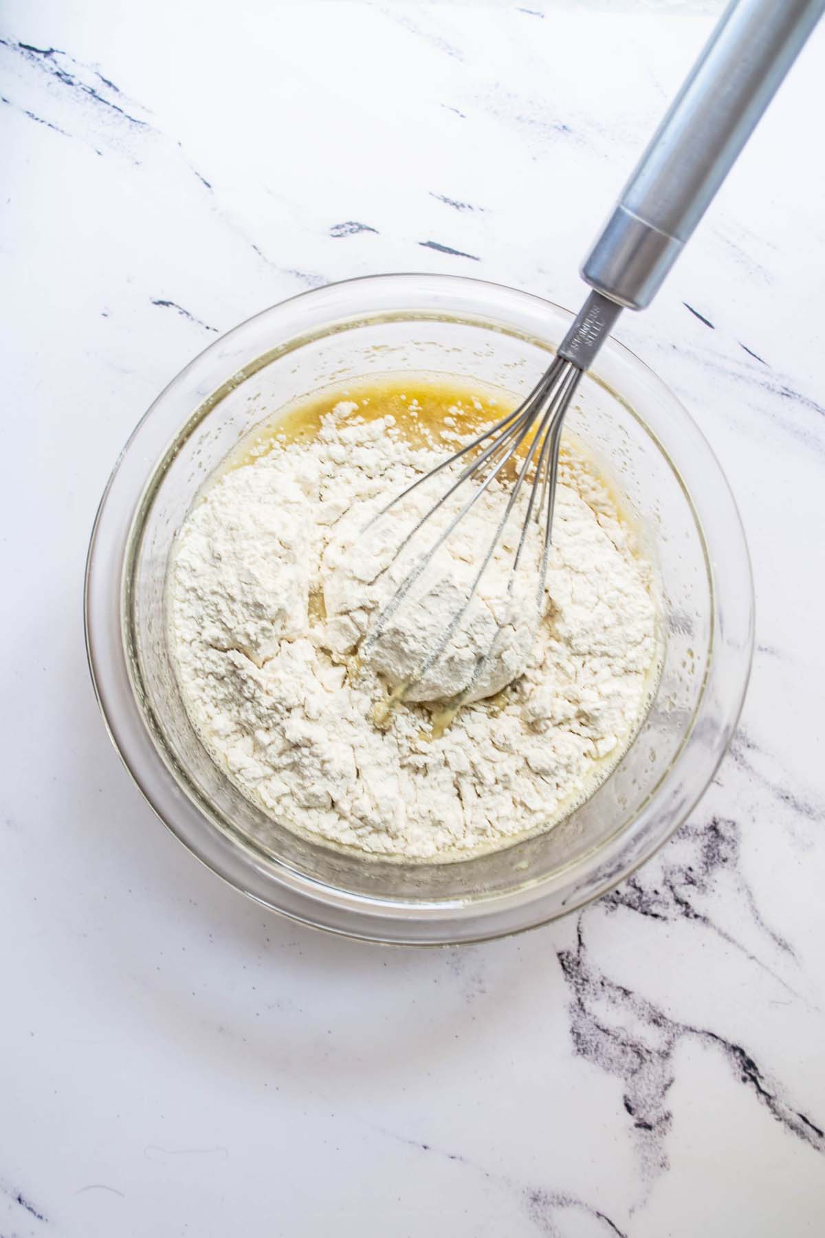 The flour added to the mixing bowl with the wet ingredients.