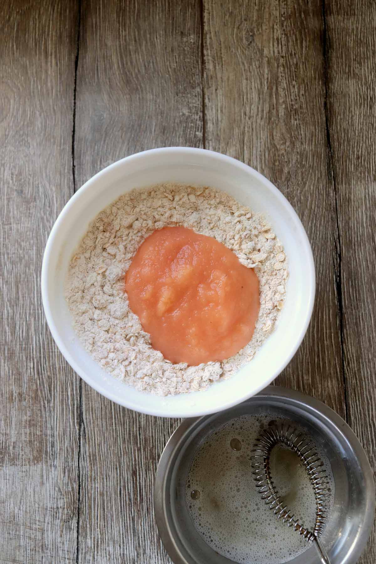 Applesauce added to the bowl of flour and oats.