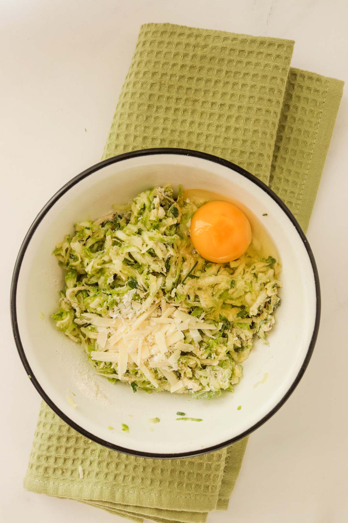 An egg and parmesan cheese added to the grated zucchini.