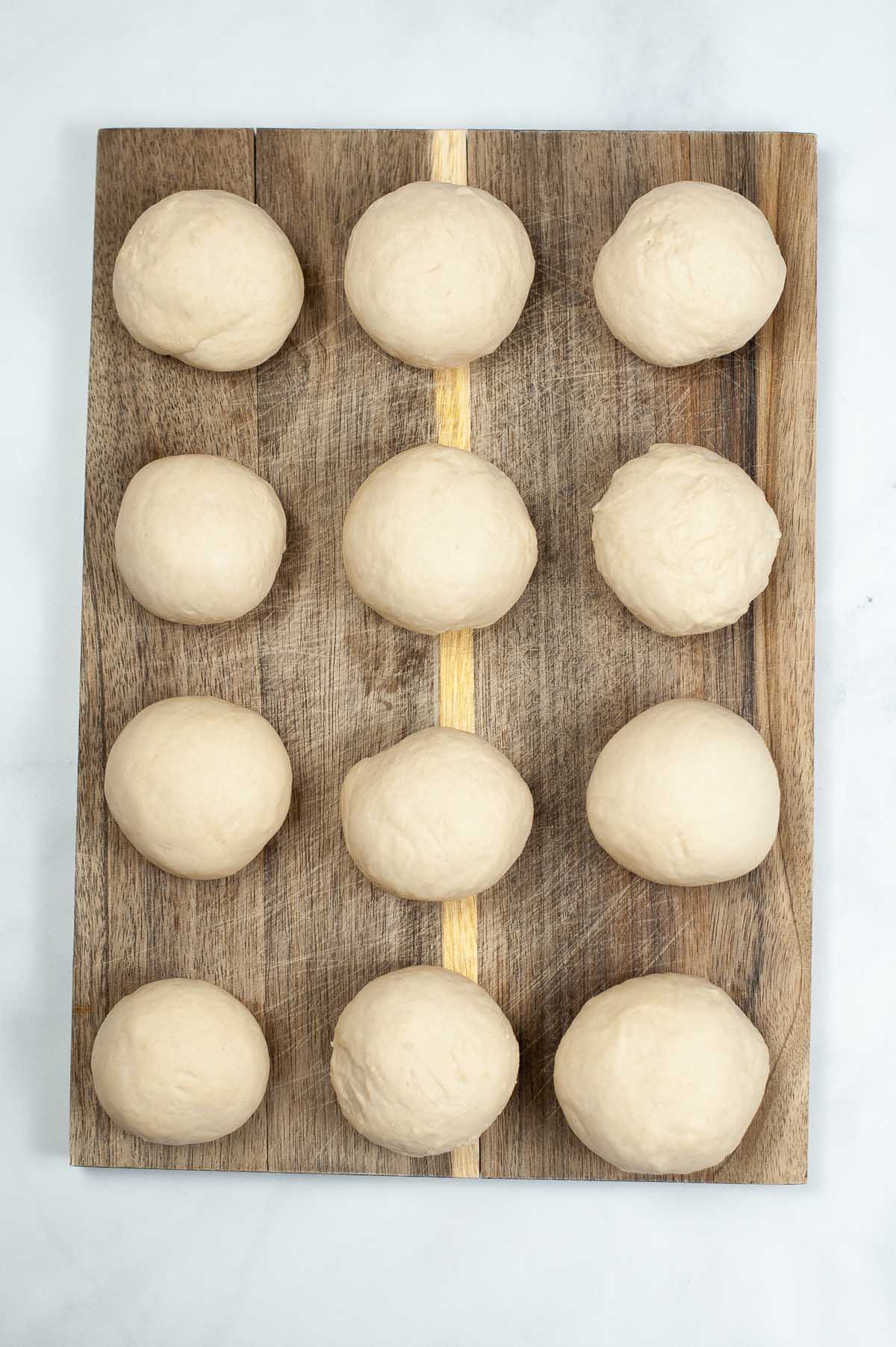 Small golf ball sized dough balls on a cutting board.