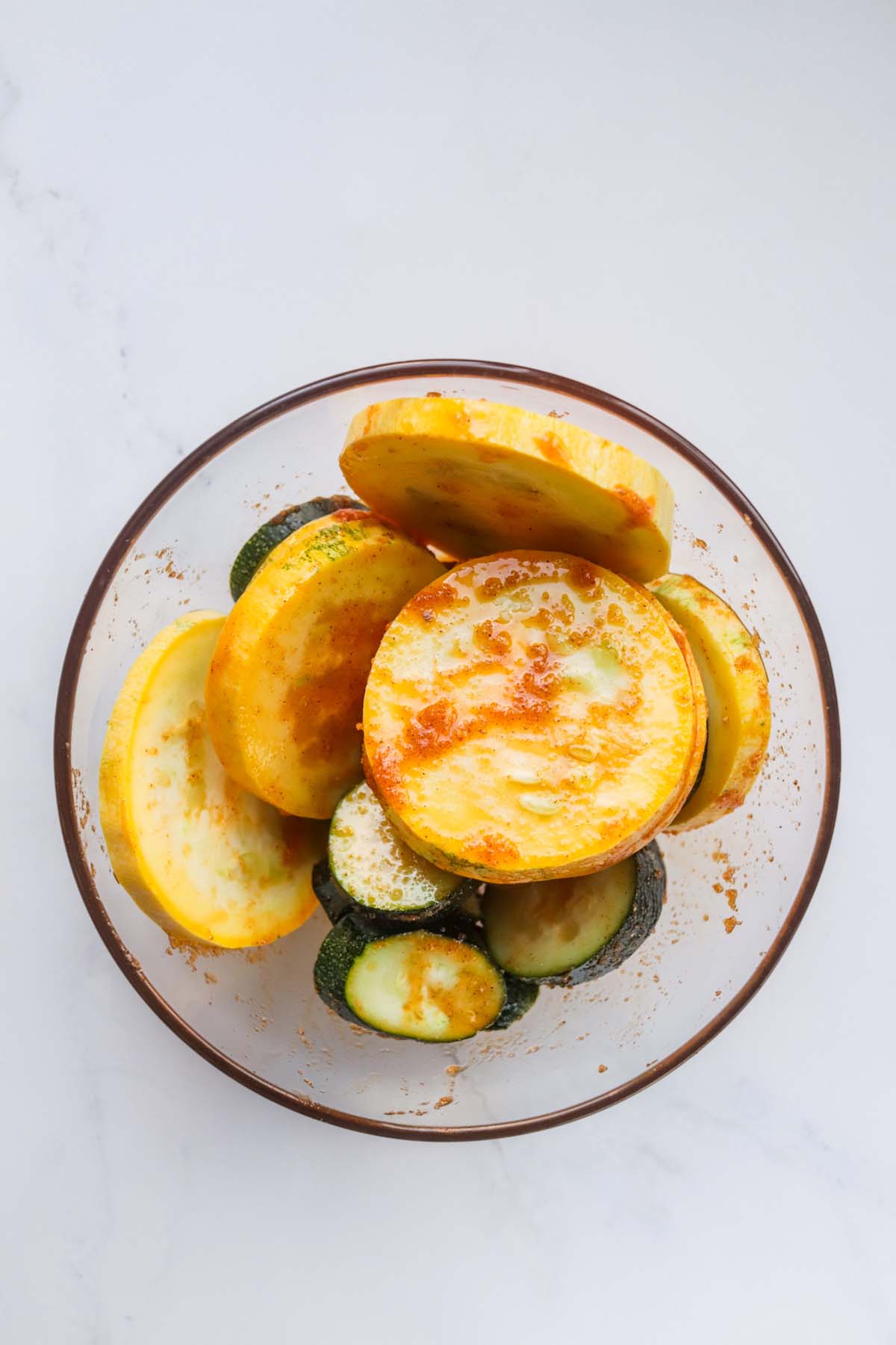 Squash slices mixed with the seasoning.