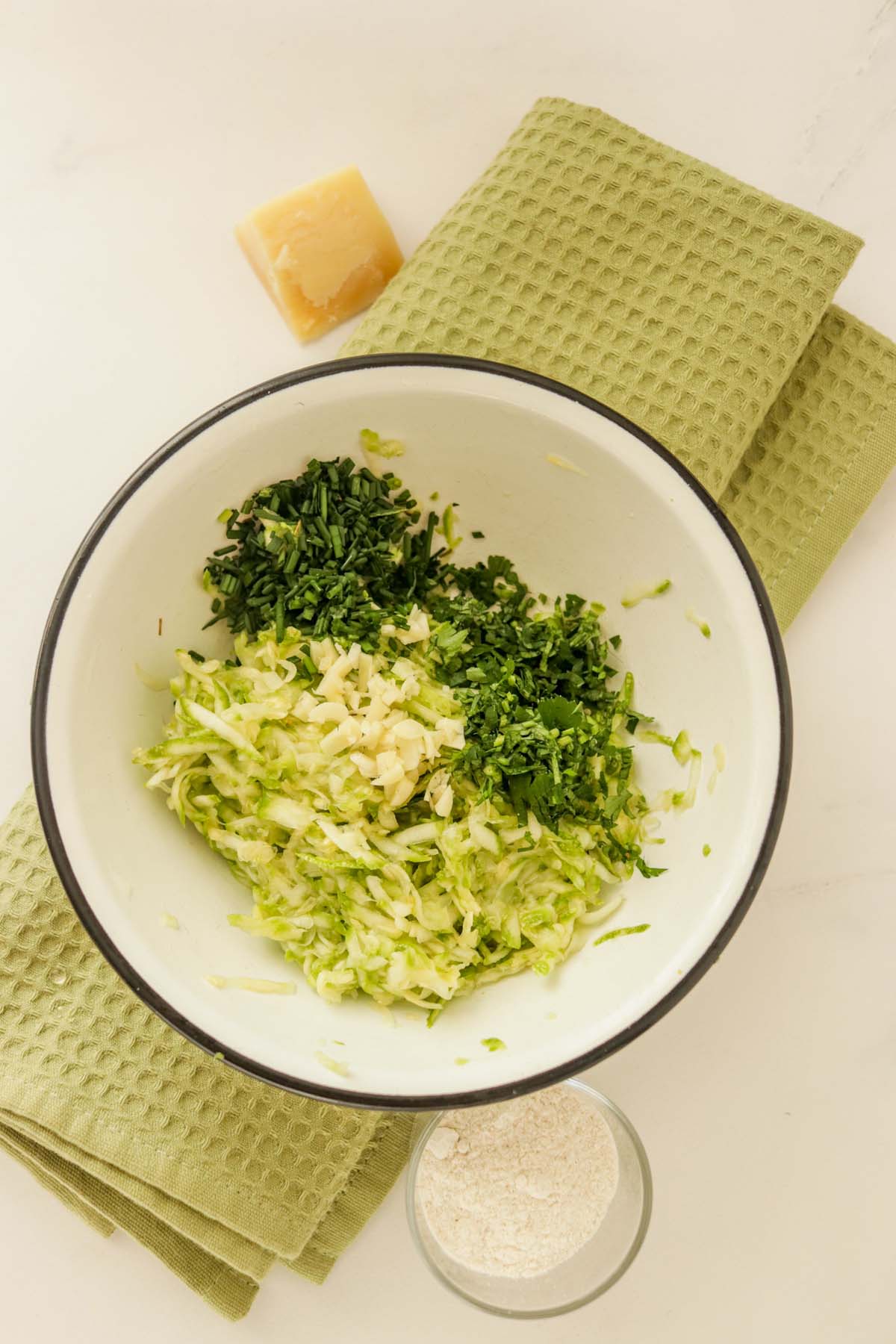 Grated zucchini and scallions in a bowl.