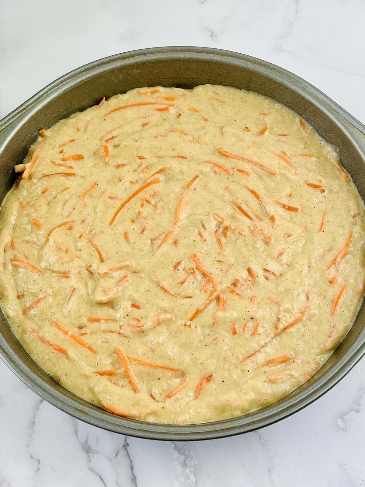 Carrot cake batter in a cake pan.