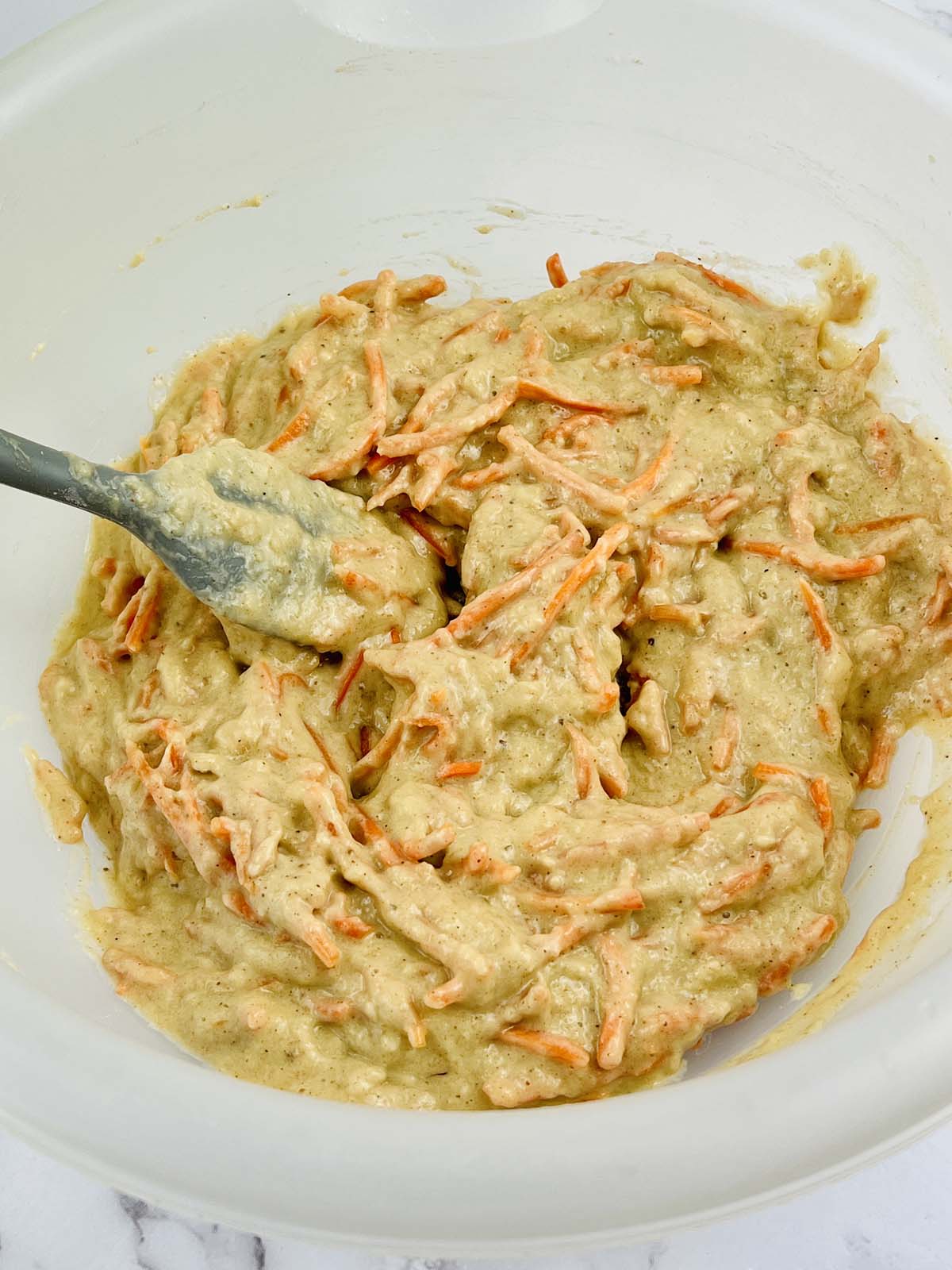 Carrot cake batter mixed together in a bowl.