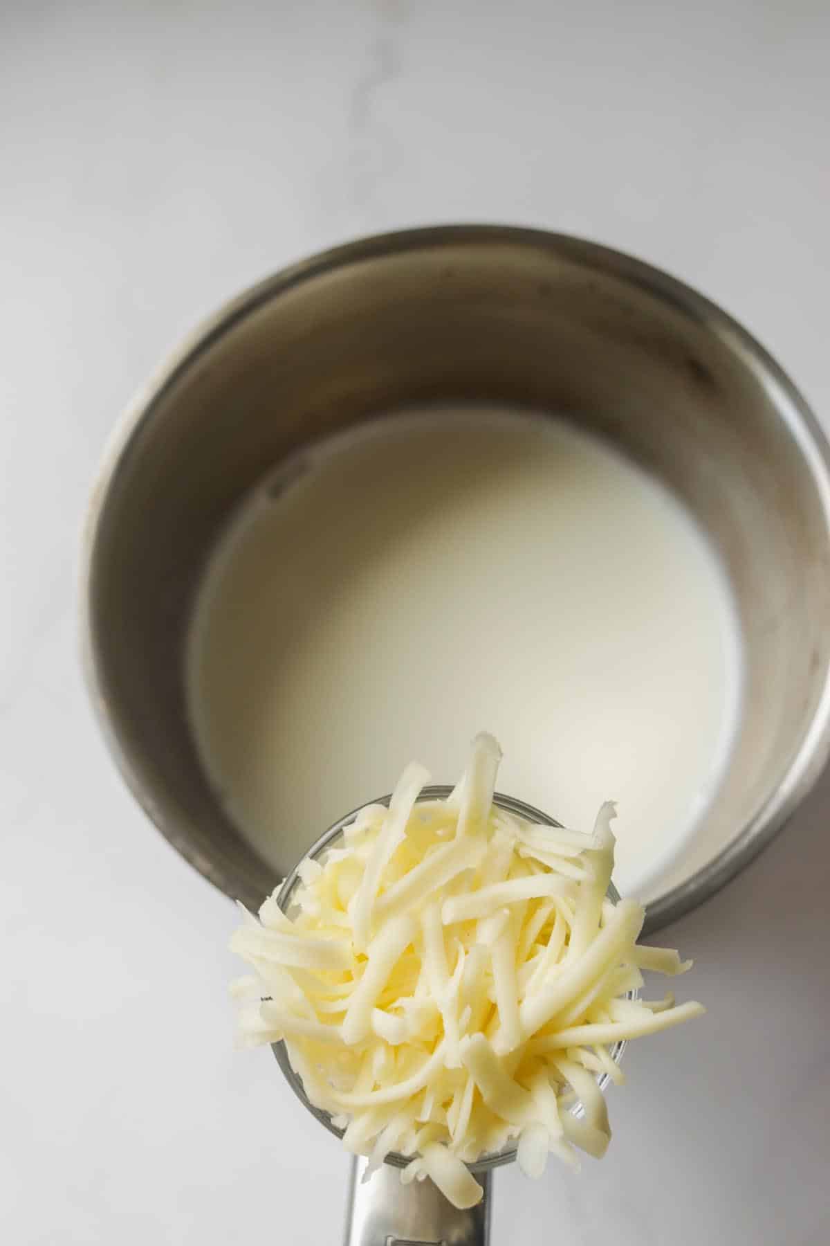 Shredded cheese being added to the milk.