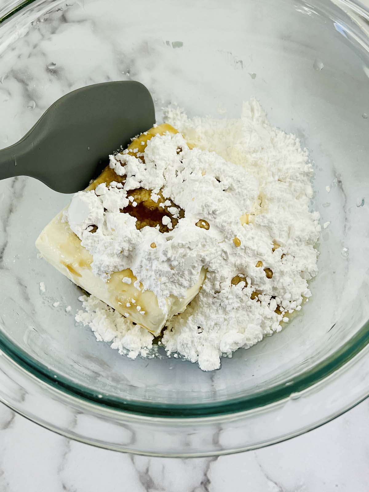Cream cheese and powdered sugar in a mixing bowl.