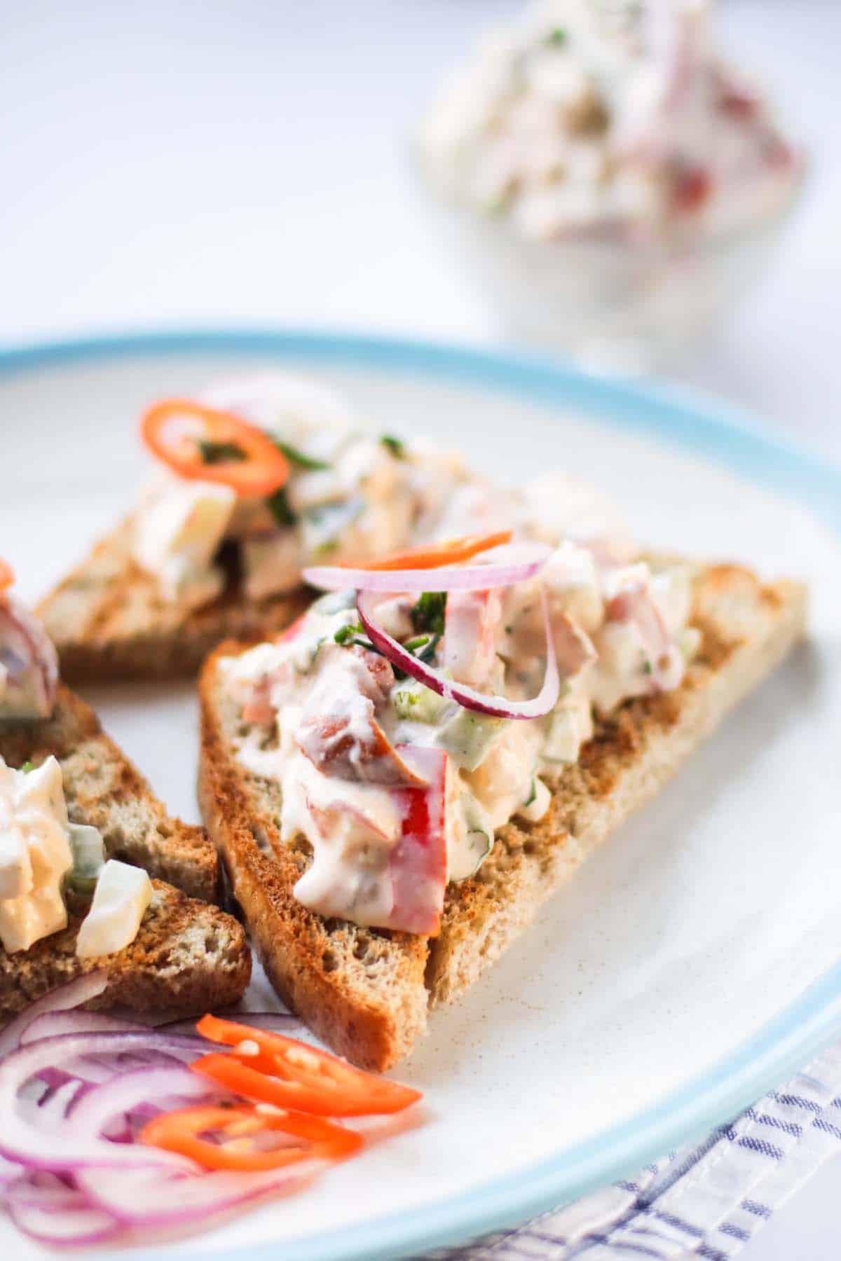 Egg salad toast on a plate.