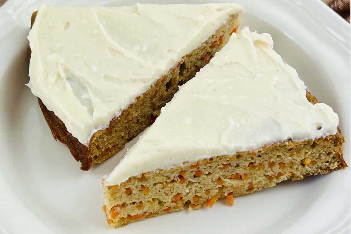 Two slices of carrot cake on a plate.