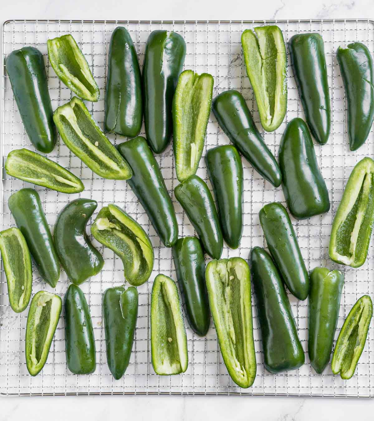 Cleaned halved jalapeños on a dehydrator tray