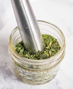 Using a muddler to crush dehydrated jalapeños