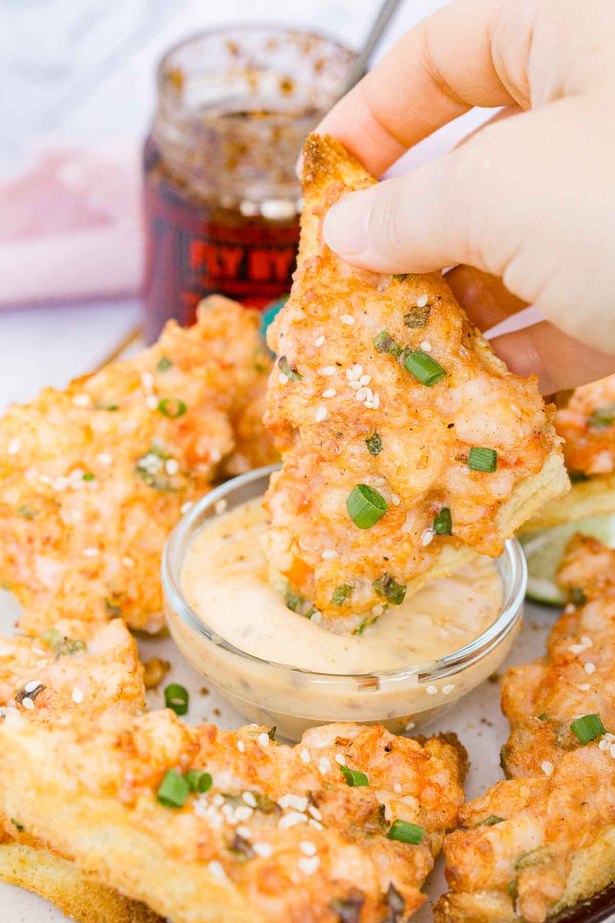 Dipping shrimp toast into spicy mayo dip